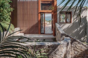Costa TerraForm exterior stone walls on a modern entry with tropical landscaping and ocean views
