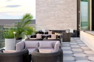 Halo STRATA limestone exterior stone wall panels on a modern outdoor terrace with patterned stone flooring and lounge seating