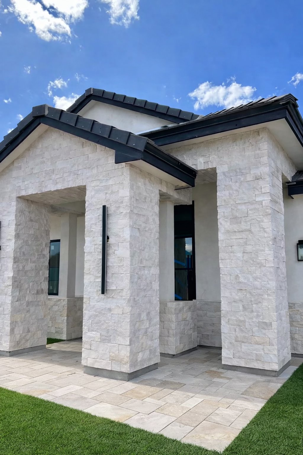 Luna Splitface Stone veneer on exterior walkout with tile roof, green grass, and linear lights