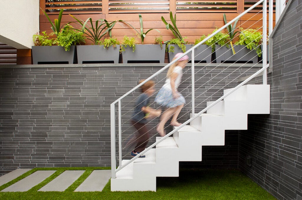 Grey Basalt Linear Wall Cladding behind White Staircase with Rectangular Stepping Stones