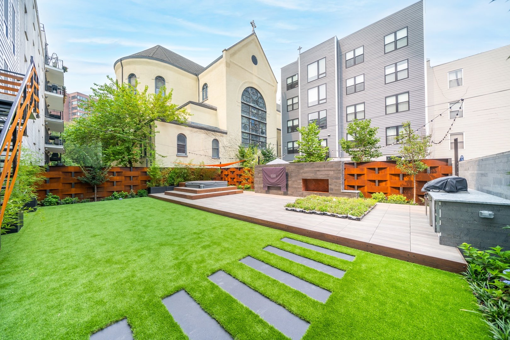 Outdoor Amenities space in Mixed Use Condo in New Jersey with Grey Linear Wall Veneer, Rectangular Basalt Stepping Stones, a Grill Island, and Wood Deck