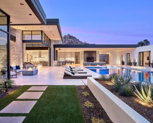 Desert Modern Residence with Warm Limestone Cladding on Walls and Stepping Stones in Turf alongside home