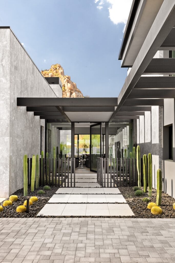 Front entrance stepping stone walkway ideas with large rectangular natural stone pavers and gravel fill at a modern home